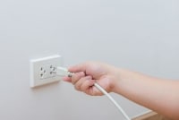 Hand Plugging In Cord To Electrical Outlet 200x134 1